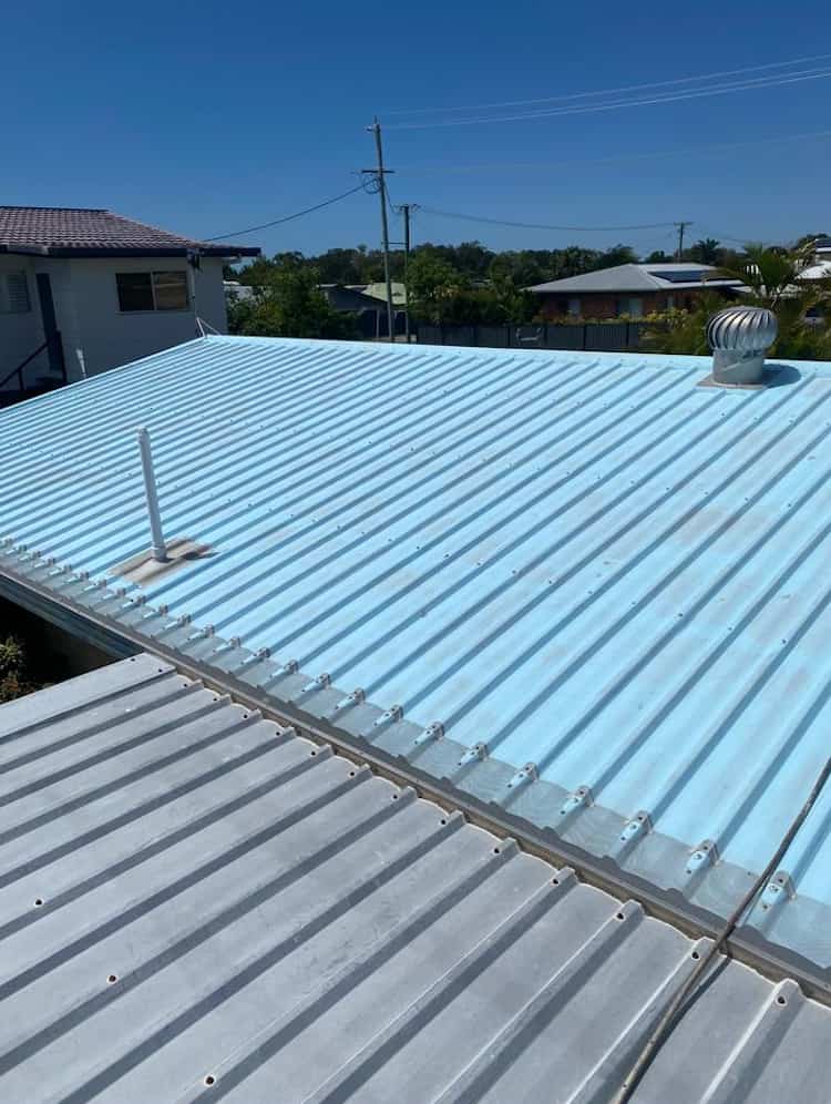 Faded light blue corrugated metal roof prior to roof painting and restoration